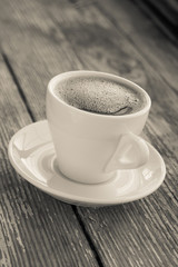White cup of coffee on a natural old wooden background. Selective focus. With copy space