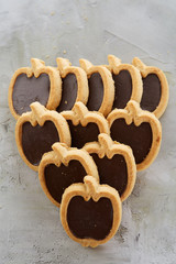 Apple shaped biscuits arranged in rows on light textured background, close-up, shallow depth of field, selective focus.