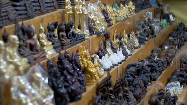 Counter with Thai souvenirs in the night market of Jomtien. Thailand. Pattaya. A variety of national souvenirs with images of elephants, buddhas, phalos and others.