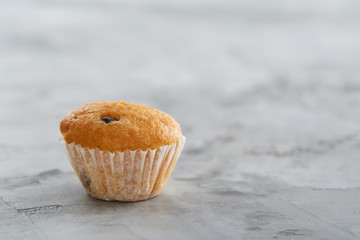 Tasty muffins arranged in pattern on light textured background, close-up, shallow depth of field, selective focus.