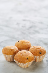 Tasty muffins arranged in pattern on light textured background, close-up, shallow depth of field, selective focus.