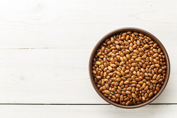 brown beans in a plate on a wooden background