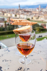 Dessertwein in Gläsern und Mandelkekse vor Panorama von Florenz