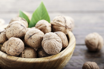 walnuts in a bowl on a wooden background