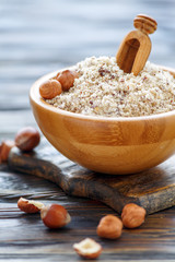 Hazelnut flour and wooden scoop in a bowl.