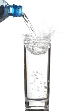 Pouring water into glass isolated on white