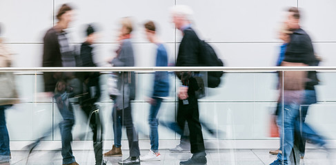 large blurred anonymous people walking in a corridor