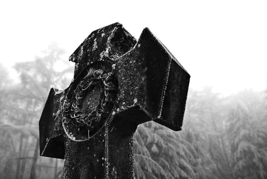 Graves with crosses at winter cemetery in black and white image