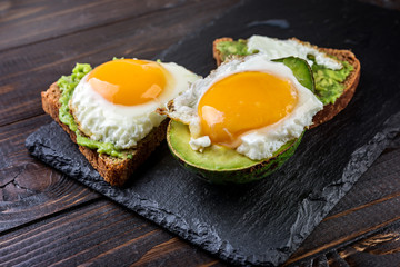 Avocado and egg  toast on a rustic wooden background