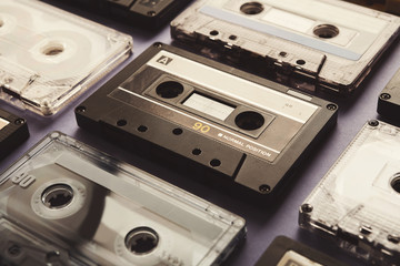Vintage audio cassettes on violet background, closeup