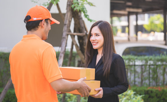 Delivery man in orange bringing woman the package