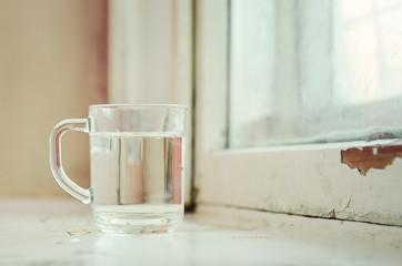 Glass of pure water on windowsill.