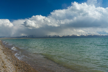 Wonderful view of the mountain lake Son-Kul with blue sky and unique clouds