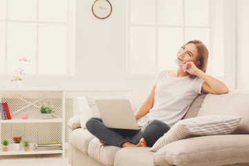 Fototapeta premium Happy thoughtful young girl with laptop indoors