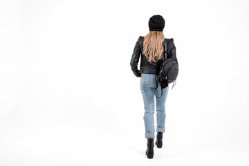 Naklejka premium Sexy hipster woman in jacket, jeans stand on white background with place for text. gorgeous girl in boots and hat with bag