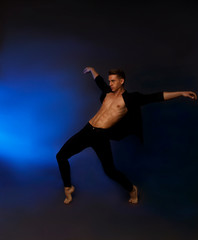 Fototapeta na wymiar A professional dancer in black trousers, dances