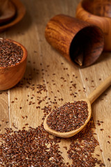 An overturned wooden bowl with linseeds on a rustic background, close-up, shallow depth of field, selective focus