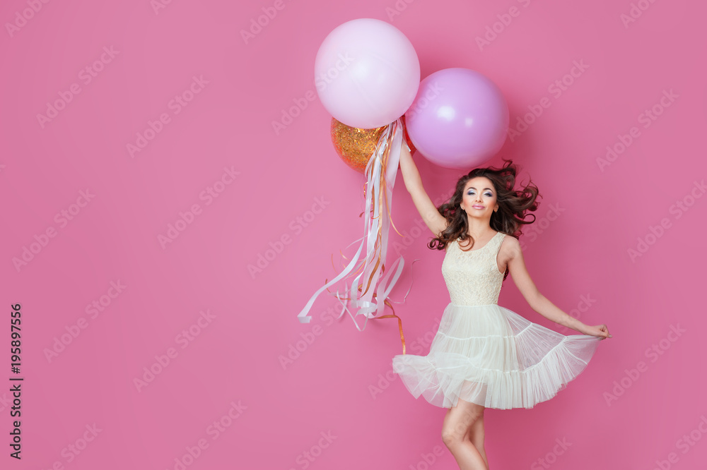 Wall mural cheerful beautiful young girl in dress with sparkle and pink helium balloons enjoying birthday photo