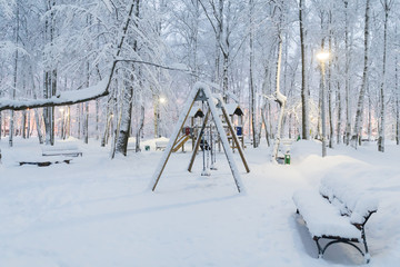 Heavy snowfall in Moscow, children's playground under the snow. Collapse of public services