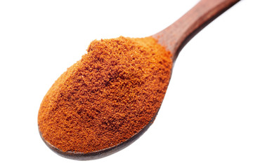 Top view of a wooden spoon full of paprica isolated on white background, shallow depth of field.