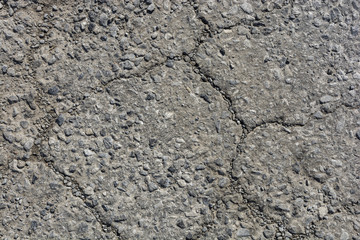 Old worn and cracked asphalt with cracks