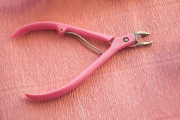 Nail clippers for cuticle isolated on pink background. Manicure tool.