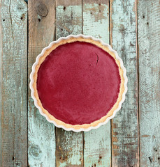 Bright delicious lingonberry open pie on shabby wooden blue background copyspace
