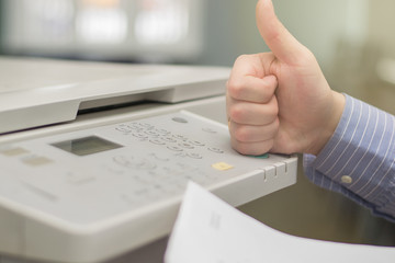 close-up of a hand of a young office manager with a finger up on a multifunction printer or copier