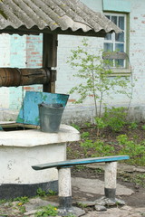 Obraz premium pit (well) near the old house in garden
