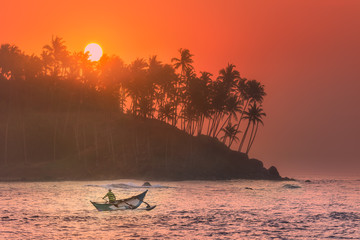 Tropical beach on sunset with fishermen and sea