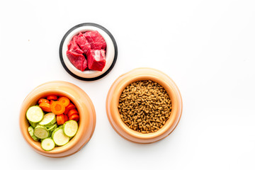 Ingredients for dry pet food. Meat and vegetables zucchini and carrot on white backgroud top view copy space