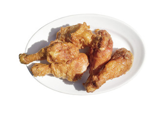 Fried chicken drumsticks isolated on white plate.