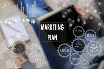 MARKETING PLAN on the touch screen with a blur the girl with the gadget, background .The concept of MARKETING PLAN