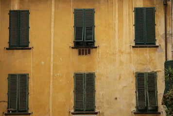 green wooden windows on the yellow wall Florence Italy