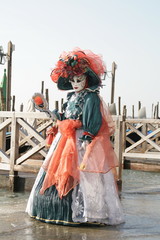 Obraz premium woman in beautiful red green and white masquerade dress and mask at the Venice carnival Italy
