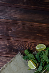 Bundle of fresh mint and lime slice  on a napkin on an old wooden background.