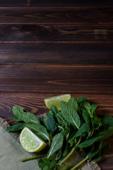 Bundle of fresh mint and lime slice  on a napkin on an old wooden background.