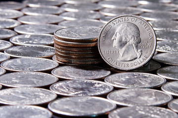 Blurry dice rolled over silver US currency quarters in a uniform pattern 1