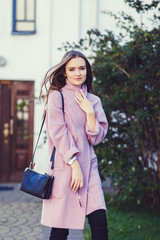 Summer sunny lifestyle fashion portrait of young stylish woman walking on street,wearing trendy coat