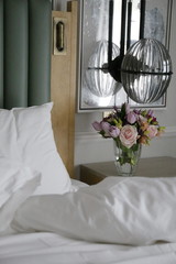 the bouquet of pink spring flowers of tulips and roses near the bed in the bedroom. hello spring, march 
