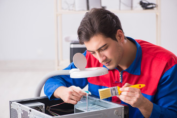 Professional repairman repairing computer in workshop