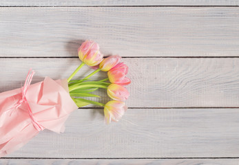 Bouquet of pink tulips on white wooden table