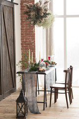 Interior design with glasses of wine water candles on a table near the bed in the bedroom or kitchen and dried flowers and plants