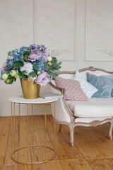 white sofa with pink and blue pillows near the white wall in spring luxury decorated appartment