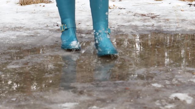 Standing in puddle in rubber boots, spring, melting snow.