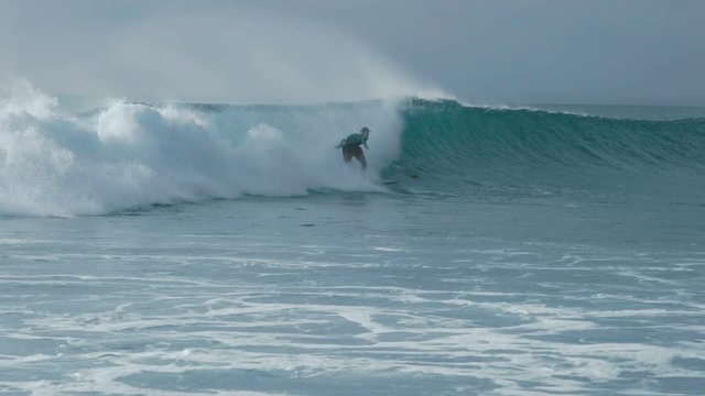 Surfer riding a wave blue ocean. Balangan Beach, Bali, Indonesia - January 2018