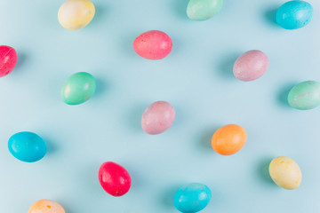 Preparation for Easter. Сolored eggs on a blue background, flat lay and top view.