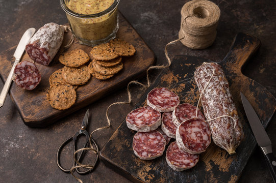 Hot and spicy salamis are paired with crackers and spicy mustard for the perfect appetizer