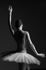 Young beautiful ballerina is posing in studio