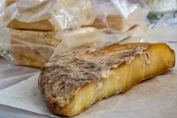 Big heads of yellow cheese on a wooden table. Cheese production.